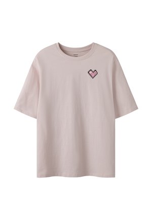 Camiseta de manga corta de color rosa claro con un pequeño corazón rosa pixelado en el lado izquierdo del pecho y un cuello redondo.