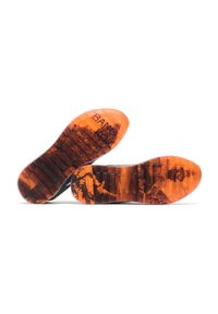 Sneaker soles in translucent orange rubber with dark textured patterns. Features ridged sole and printed graphics on the surface.
