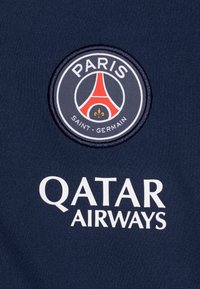 Marinblå sportströja med en rund broderad Paris Saint-Germain-logotyp och vit text "Qatar Airways" under.