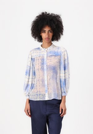 Gjennomsiktig knapp-up blouse i lys blå og hvit, med blomster mønstre, krage og puffer lange ermer; brukt med marineblå bukser.