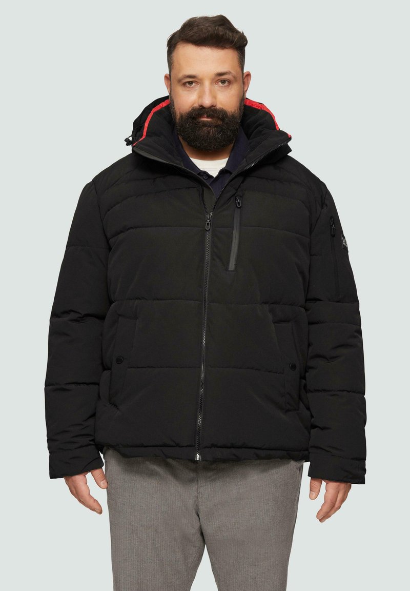 Schwarze gepolsterte Jacke mit Kapuze, mit rotem Innenfutter, mit Reißverschluss vorne, zwei seitlichen Taschen und einer zusätzlichen Reißverschluss-Tasche am linken Ärmel.