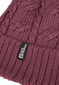 Beanie in magenta scuro lavorato a maglia con un bordo a coste e un motivo a trecce testurizzato. Include un'etichetta nera con logo bianco.