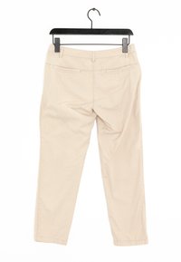Chinos en coton beige avec une coupe droite, dotés de poches avant et arrière, et de détails cousus le long des coutures. Accrochés à un cintre noir.