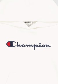 Felpa bianca con cappuccio realizzata in tessuto morbido, caratterizzata da un logo "Champion" ricamato in navy e un accento rosso sulla lettera "C". Vestibilità standard.