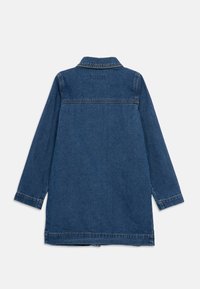 Casaco de ganga, comprimento médio, azul escuro, mangas compridas, gola pontiaguda e pala traseira. Apresenta costuras visíveis e fendas laterais na bainha.