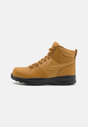 Bota de senderismo de cuero marrón con puntera redonda, suela de goma negra, cordones en la parte delantera, cuello acolchado en el tobillo y logo de Nike en el lateral.