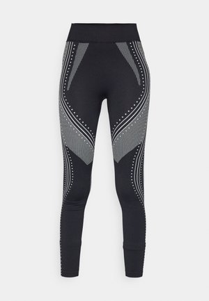Leggings pretas com uma cintura larga, apresentando padrões e acentos em prata metálica, incluindo linhas e pontos, ao longo dos lados.