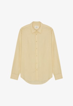 Langærmet skjorte med knapper i lysegult stof med en glat tekstur, der har klassisk krave og buet kant.