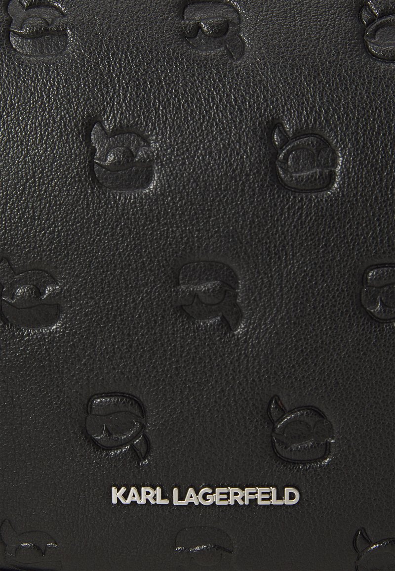 Portefeuille en cuir noir avec logos Karl Lagerfeld embossés, branding argenté, surface texturée et forme rectangulaire compacte.