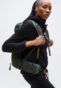 Πράσινο και μαύρο σακίδιο πεζοπορίας με ρυθμιζόμενους ιμάντες, υφασμένες πλαϊνές τσέπες και επενδυμένη πλάτη για άνεση και υποστήριξη.