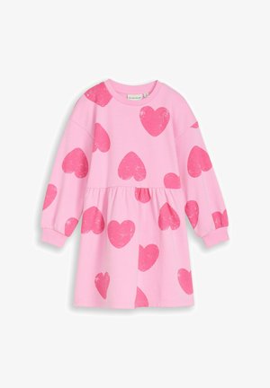 Roze jurk met lange mouwen en een geplooide taille, voorzien van grote verweerde rode hartafdrukken gelijkmatig verdeeld over de stof.