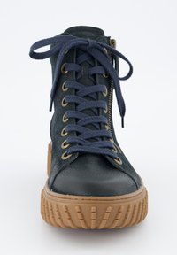 Baskets montantes en suédé vert foncé, avec des lacets navy, des œillets dorés, une fermeture éclair sur le côté et une semelle en caoutchouc texturé.