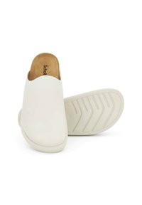 Sabots blancs à enfiler avec une finition lisse, un orteil arrondi et une semelle extérieure en caoutchouc texturé. L'intérieur en liège offre confort et soutien.