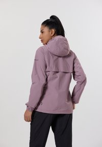 Ljuslila dragkedjepocket med huva, elastiska muddar och ventilerad rygg. Tillverkad av ett lätt, vattenavvisande material.