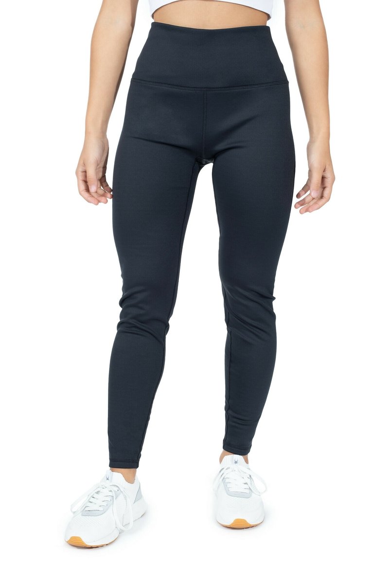 Zwarte hoge taille legging met een gladde textuur, getailleerd ontwerp en rekbare stof, gecombineerd met witte sportschoenen.