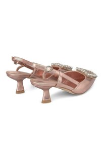 Scarpe slingback color oro rosa con finitura metallica, tacco basso a campana e decorazioni di cristalli trasparenti sulla zona della punta.