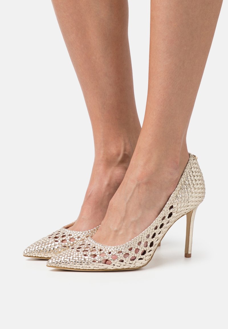 Scarpe con tacco a spillo in maglia metallizzata oro, con punta affusolata e design a rete aperta, caratterizzate da un elegante tacco stiletto per un'altezza aggiuntiva.