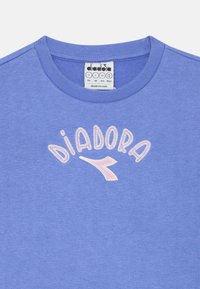 Blauer Baumwoll-Sweatshirt mit geripptem Rundhalsausschnitt, versehen mit gesticktem "DIADORA"-Text und Logo in Pink und Weiß über der Brust.