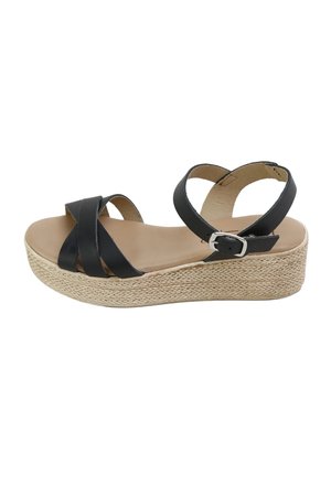 Sandalia de cuña negra con tiras cruzadas, hebilla en el tobillo y plataforma entrelazada.