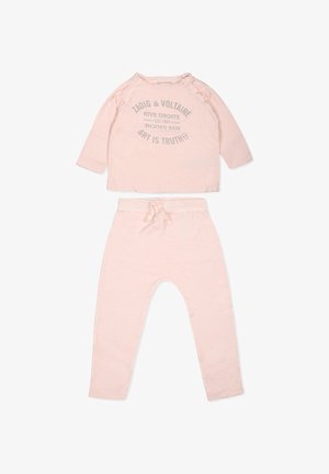 Ensemble deux pièces rose clair comprenant un haut à manches longues avec du texte gris et un pantalon avec une taille élastique et un cordon de serrage. Texture de tissu douce.