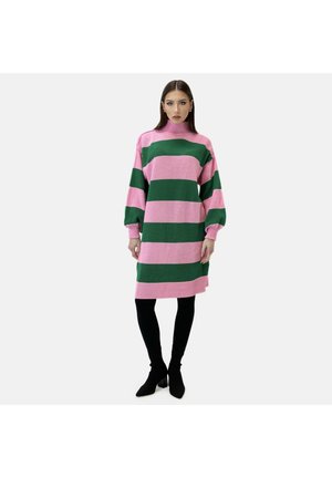 Robe tricotée avec des rayures horizontales roses et vertes, col haut, manches amples et poignets côtelés, associée à des leggings noirs et des chaussures pointues.