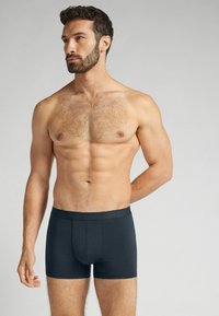 Herrarnas mörkgrå boxerkalsonger med en slät textur och elastisk midja, med en design för framfickan och ett åtsittande snitt.