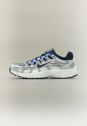 Widok z boku białego i granatowego buta do biegania Nike P-6000 z siateczkową i syntetyczną cholewką oraz wzorzystą podeszwą na neutralnym tle.