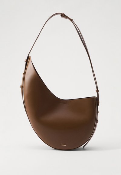 Borsa a spalla in pelle marrone con un design liscio e curvo e una sottile tracolla. Presenta un logo discreto e un'estetica minimalista.