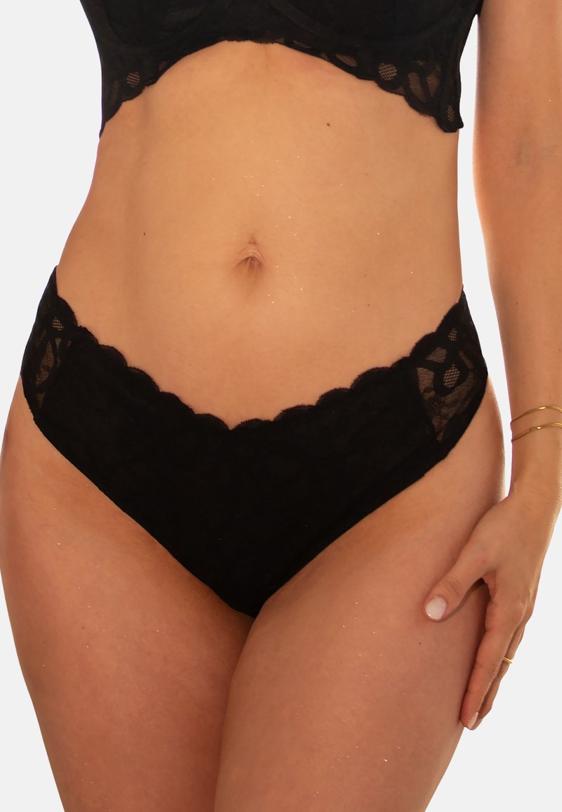 Schwarzes Spitzenunterwäsche-Set mit gewellten Kanten, transparentem Design und filigranen Blumenmustern. Der Stoff ist weich und zart.