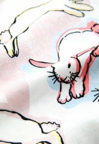 Tkanina bawełniana z powtarzającym się wzorem stylizowanych królików w kolorach różowym, żółtym i czarnym, na jasnoniebieskim i różowym tle.