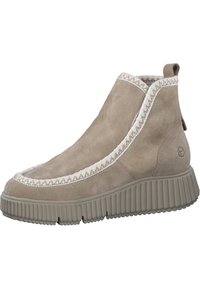 Stivaletti alla caviglia in suede beige dotati di una suola in gomma testurizzata, bordi cuciti decorativi e un pratico anello sul retro per indossarli facilmente.