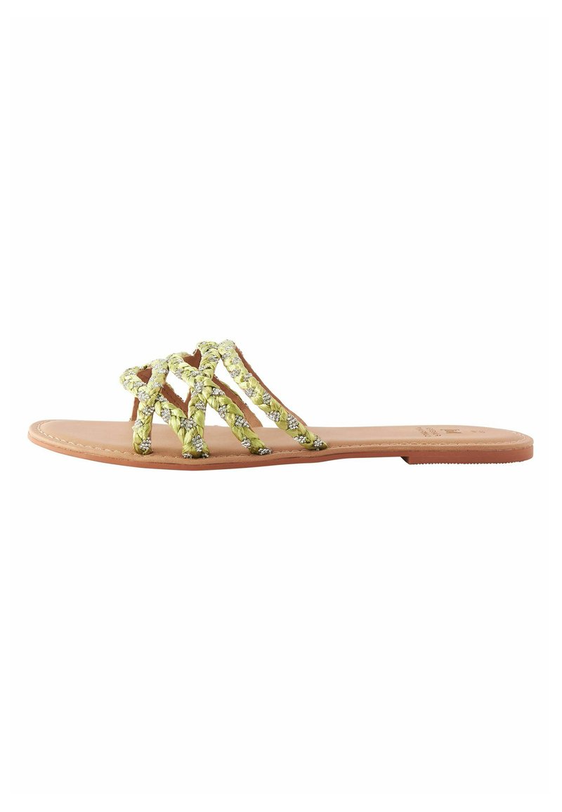 Platt sandal med en ljusbrun sula. Ovansidan har ihopflätade remmar i livfullt gult med silverdetaljer och en texturerad finish.