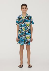 Set di camicia a maniche corte con colletto e pantaloni corti in blu, nero e giallo con stampa in stile graffiti che presenta le parole "Cool" e "Street."