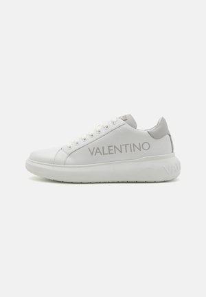 Vita lädersneakers med rund tå, upphöjd sula och grå detaljer. Har "VALENTINO"-logotypen längs den yttre sidan för varumärkeskännedom.
