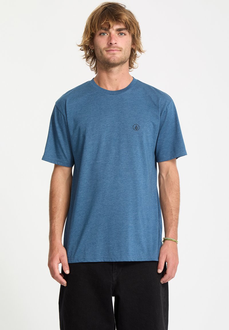 Blå kortærmet T-shirt lavet af blød stof, med rund hals og lille sort logo på venstre bryst. Casual pasform, minimalistisk design.