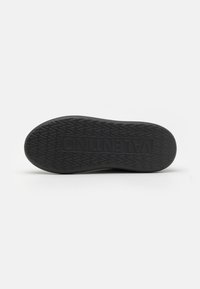 Black rubber shoe sole with a textured surface, featuring a diamond pattern and embossed "VALENTINO" logo.
