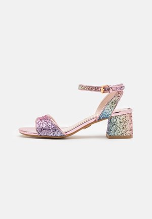 Sandalias de tacón con glitter rosa, con un tacón de bloque ancho en degradado de color, una correa en el tobillo con hebilla dorada y diseño de punta abierta.