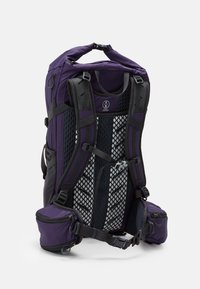 Sac à dos violet avec un dos en maille rembourrée, des bretelles ajustables, des poches latérales et une poignée supérieure. Présente un design épuré avec un tissu résistant.