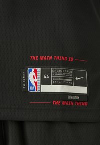 Étiquette noire de maillot NBA swingman, taille 44, logo Nike, étiquette "City Edition" et texte rouge indiquant "The main thing is ___ the main thing."