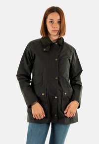 Donkergroene waterdichte jas met een corduroy kraag, drukknoopsluiting, twee voorzakken en een middellange snit. Soepele textuur, casual pasvorm.