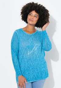 Camicia a maniche lunghe turchese con una consistenza morbida, caratterizzata da un design a stella in paillettes sul davanti e una vestibilità rilassata.
