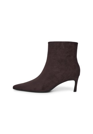 Dunkelbraune Wildleder-Stiefelette mit spitzer Schuhspitze und schlankem mittelhohem Absatz auf weißem Hintergrund.