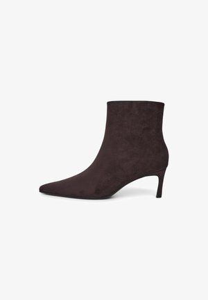 Dunkelbraune Wildleder-Stiefelette mit spitzer Schuhspitze und schlankem mittelhohem Absatz auf weißem Hintergrund.