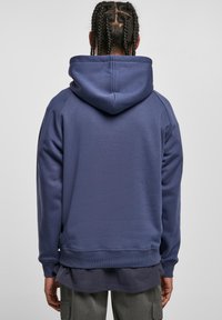 Sudadera con capucha de color azul marino con un diseño sencillo, puños y dobladillo acanalados. El material parece suave, con una textura lisa y sin gráficos visibles.
