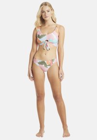 Multicolore bikini-set met een top met ronde hals, een strik aan de voorkant en uitsnede, en bijpassende low-rise onderkant in vergelijkbare patronen.