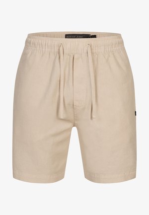 Bež shortse s teksturiranim završetkom, elastičnom strukom i trakicom za podešavanje. Oznaka branda vidljiva unutar struka. Jednostavan dizajn, bez uzoraka.