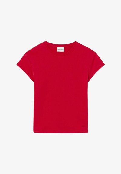 T-shirt en coton rouge à manches courtes, encolure ronde, avec un accent de logo subtil sur le bas à droite. Texture lisse, design simple.