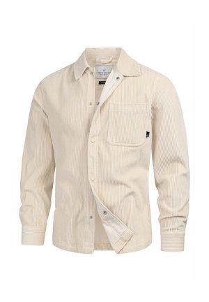Camicia in corduroy beige con colletto, tasche frontali e chiusura a bottoni. Presenta delle righe verticali e una trama morbida.