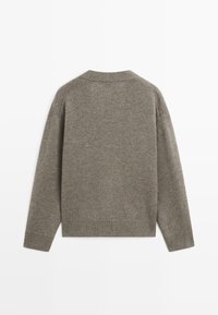 Šedý pletený svetr s dlouhými rukávy, žebrovanými manžetami a lemem, texturovaným povrchem a jednoduchým kulatým výstřihem. Pohled zezadu, bez ozdob.