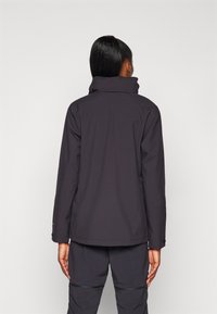 Black, water-resistant jacket with a high collar and long sleeves. Features a smooth texture and minimalistic design, suitable for outdoor wear.